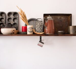 kitchen utensil lot on brown wooden floating shelf