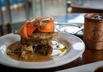 burger with tomato and lettuce on white ceramic plate