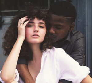 man hugging woman while taking photo of each other