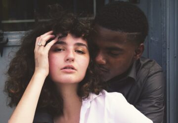 man hugging woman while taking photo of each other