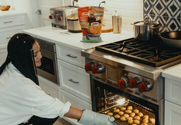 woman in white long sleeve shirt and black and white hijab standing in front of stainless