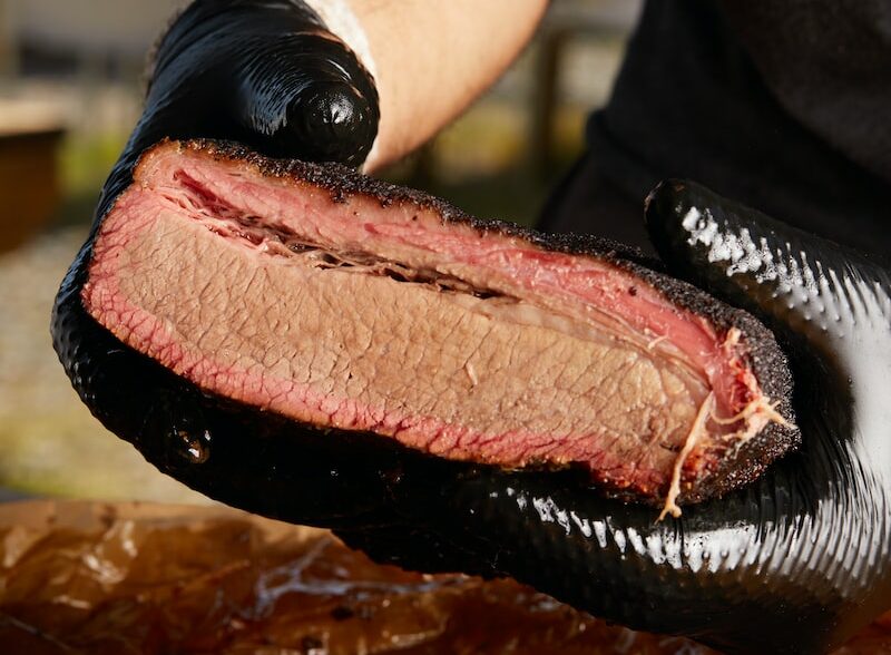 person holding raw meat during daytime