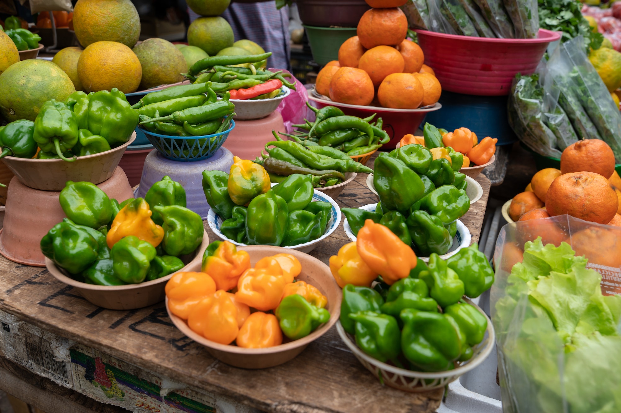 Green and orange peppers on display at a market in Mexico