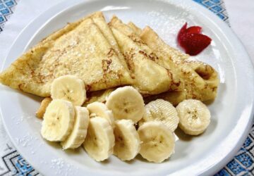 Ukrainian pancakes with banana and strawberries. Blini